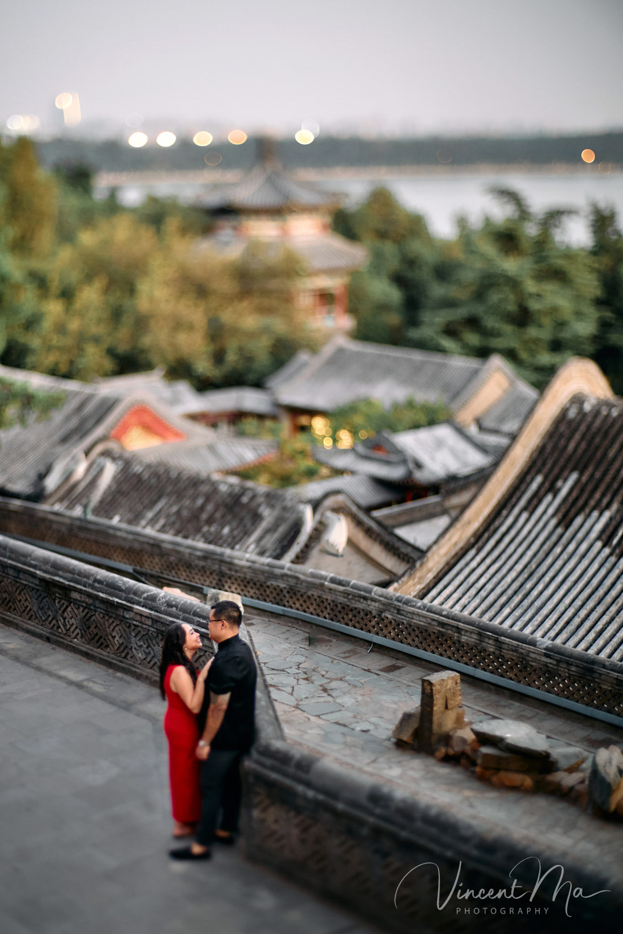 A couple enjoying an engagement photoshoot at the Summer Palace in Beijing, with traditional Chinese architecture and gardens in the background. Captured by a local Beijing photographer.