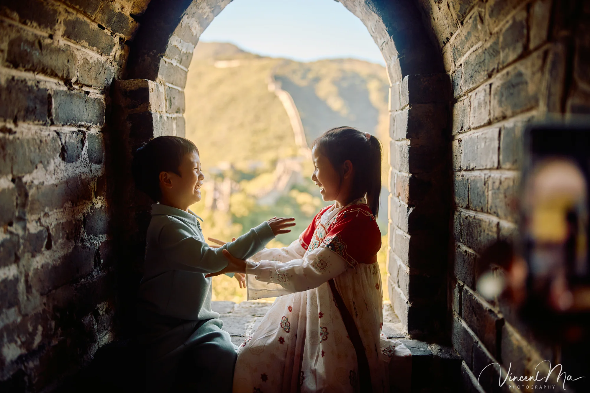 A panoramic view of the Mutianyu Great Wall during a family trip in the afternoon, showing the majestic wall winding through the mountains