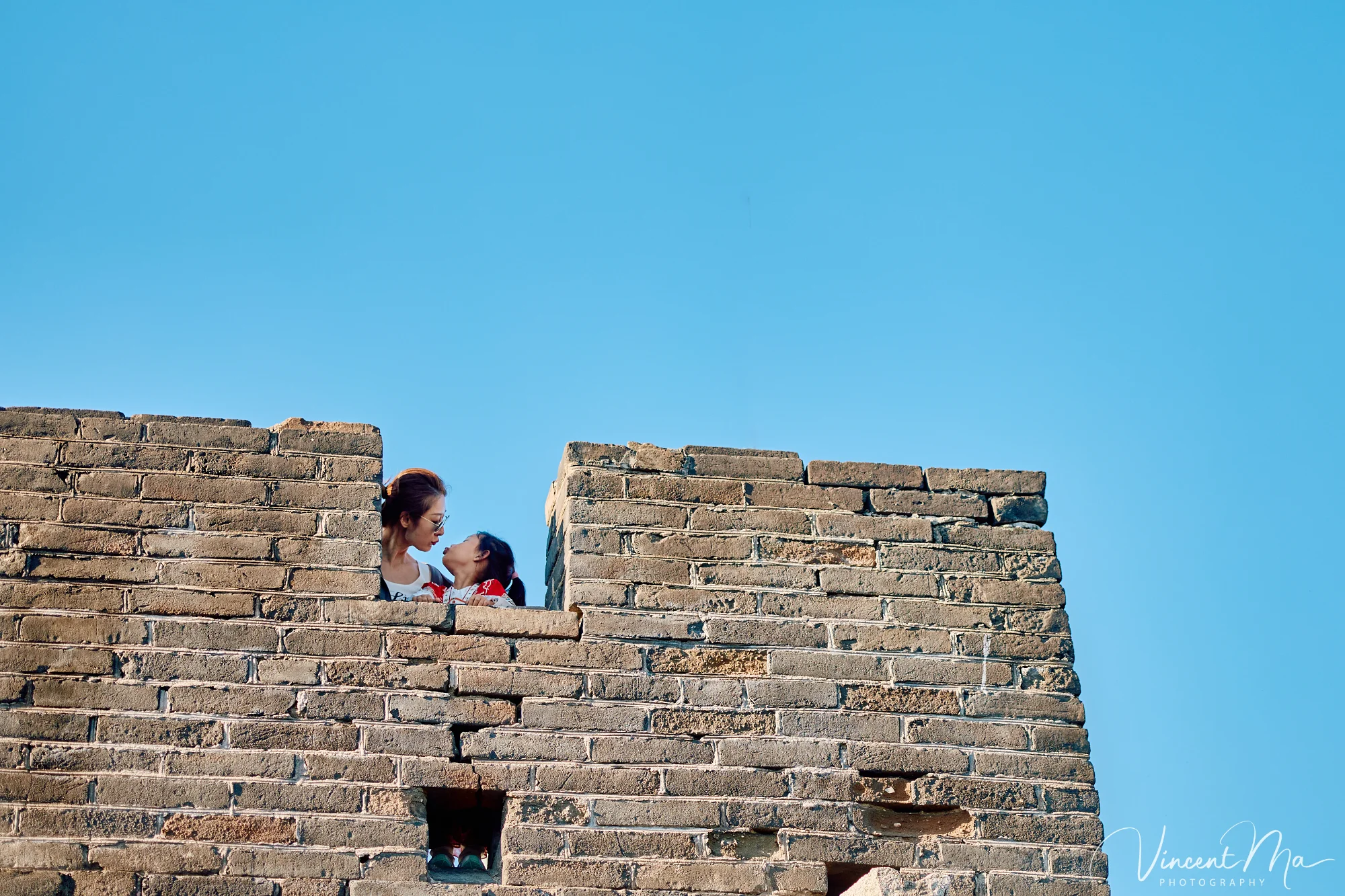 A panoramic view of the Mutianyu Great Wall during a family trip in the afternoon, showing the majestic wall winding through the mountains
