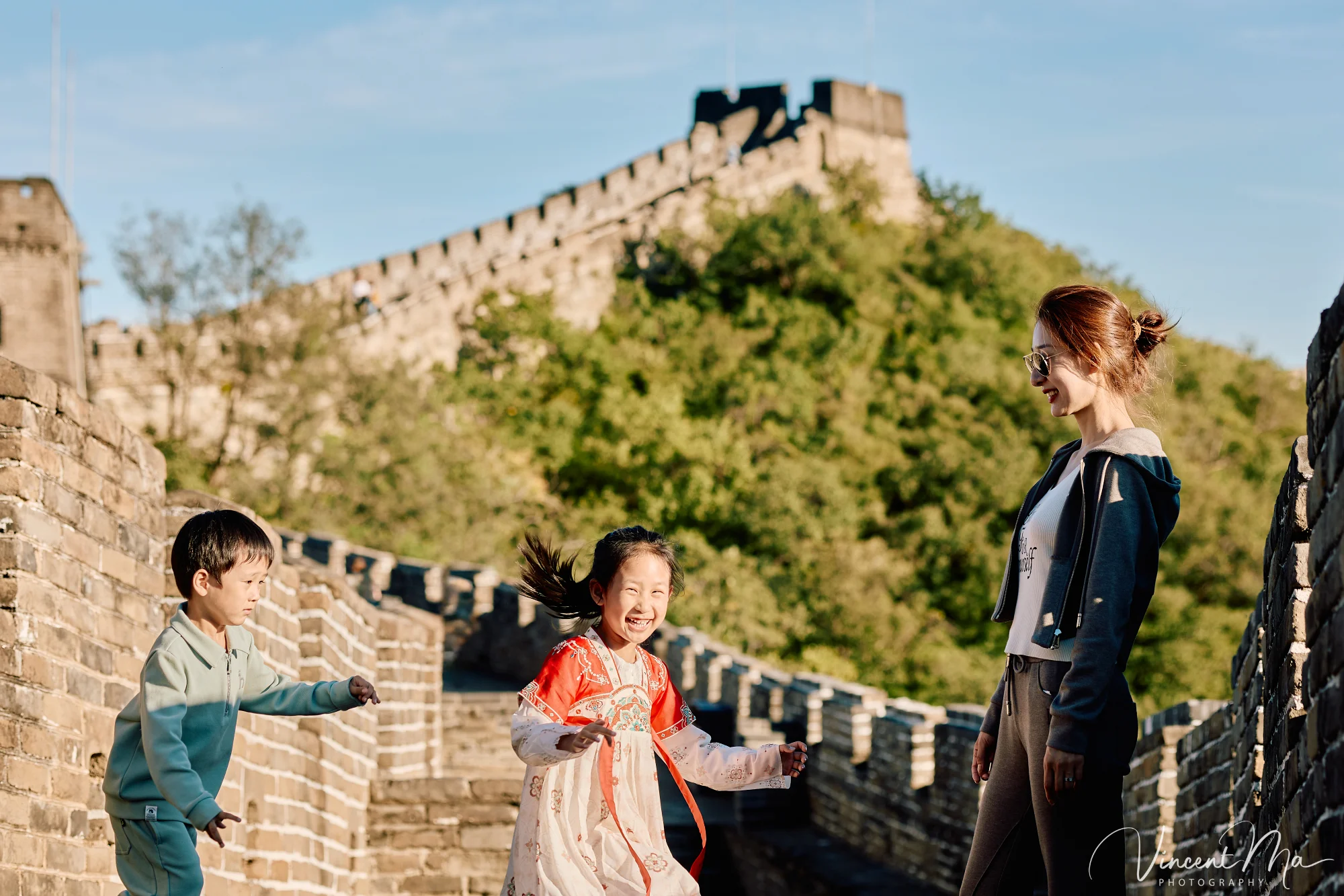 A panoramic view of the Mutianyu Great Wall during a family trip in the afternoon, showing the majestic wall winding through the mountains