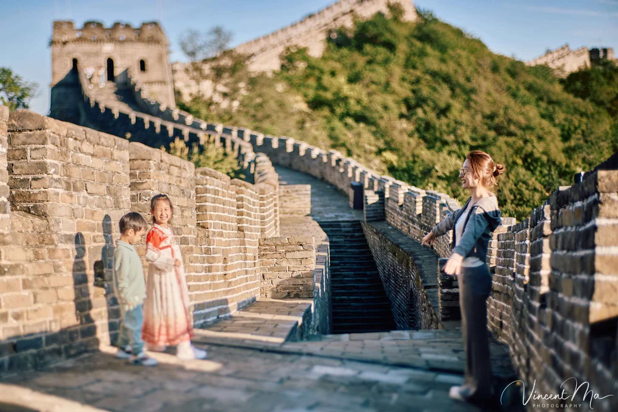 A panoramic view of the Mutianyu Great Wall during a family trip in the afternoon, showing the majestic wall winding through the mountains