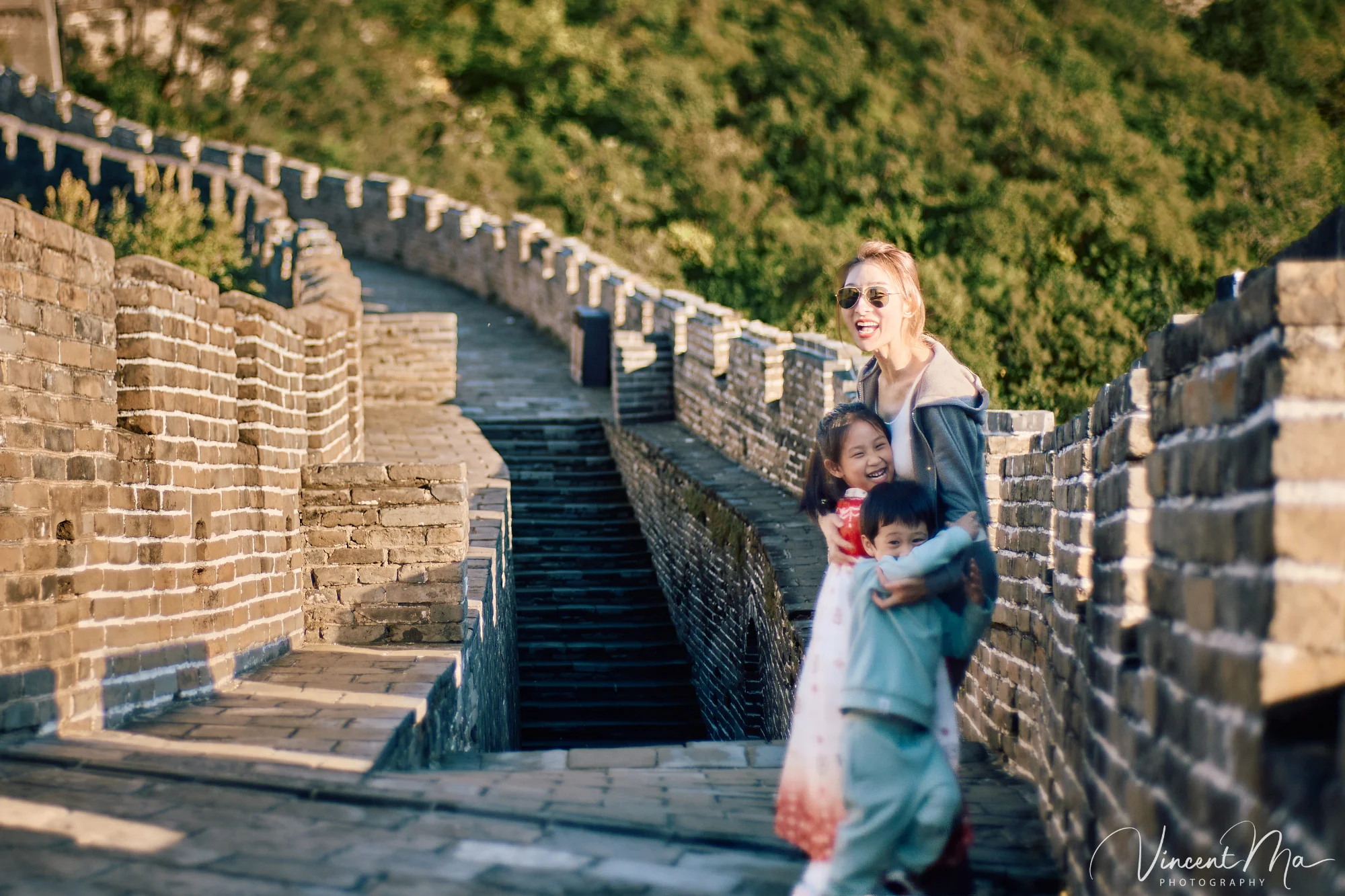 A panoramic view of the Mutianyu Great Wall during a family trip in the afternoon, showing the majestic wall winding through the mountains