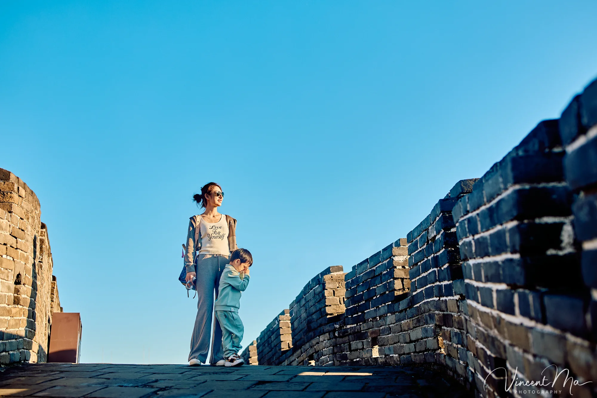 A panoramic view of the Mutianyu Great Wall during a family trip in the afternoon, showing the majestic wall winding through the mountains