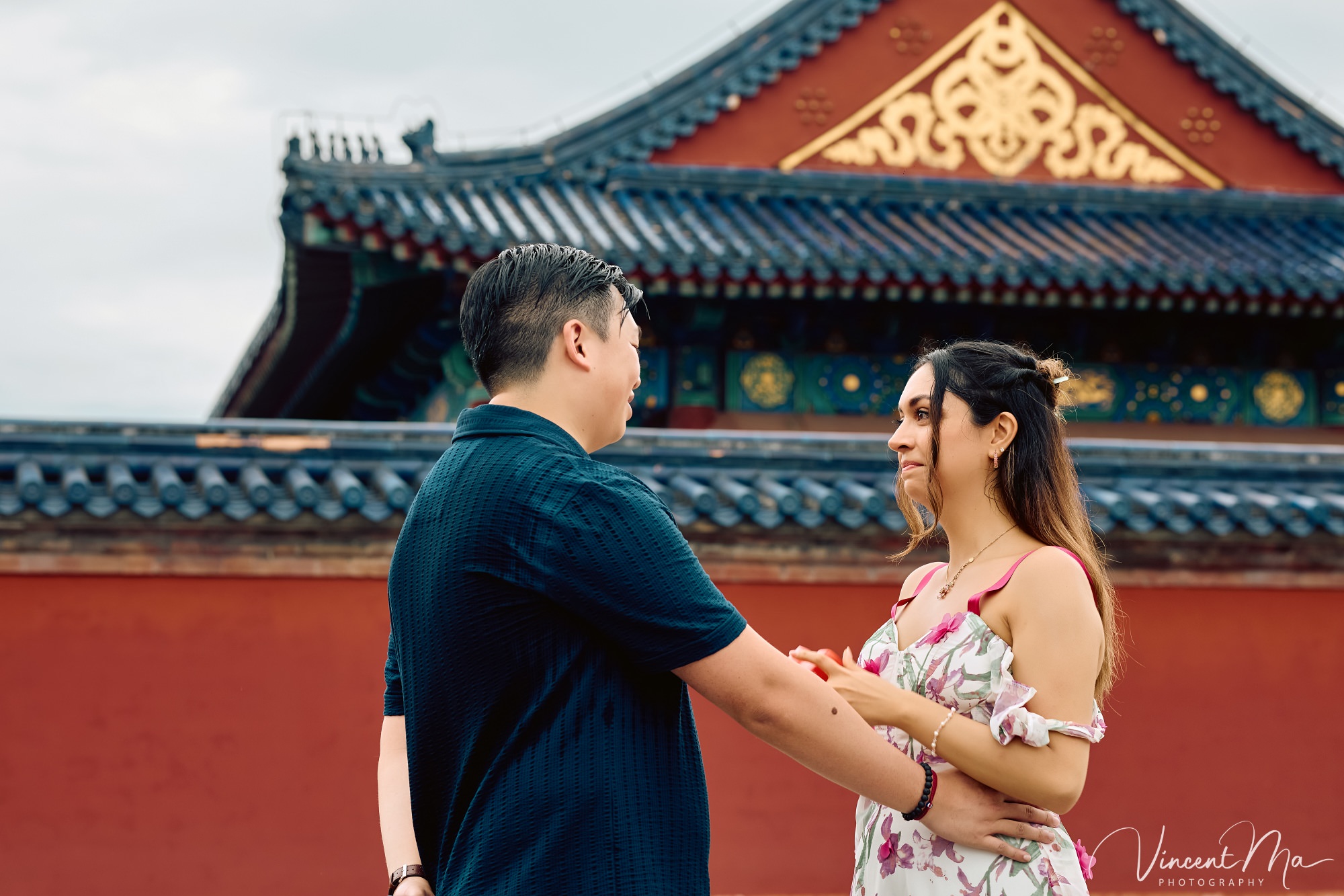 A foreign couple in traditional Chinese - style clothing, the man kneeling on one knee to propose to the woman in front of the majestic Hall of Prayer for Good Harvests in the Temple of Heaven