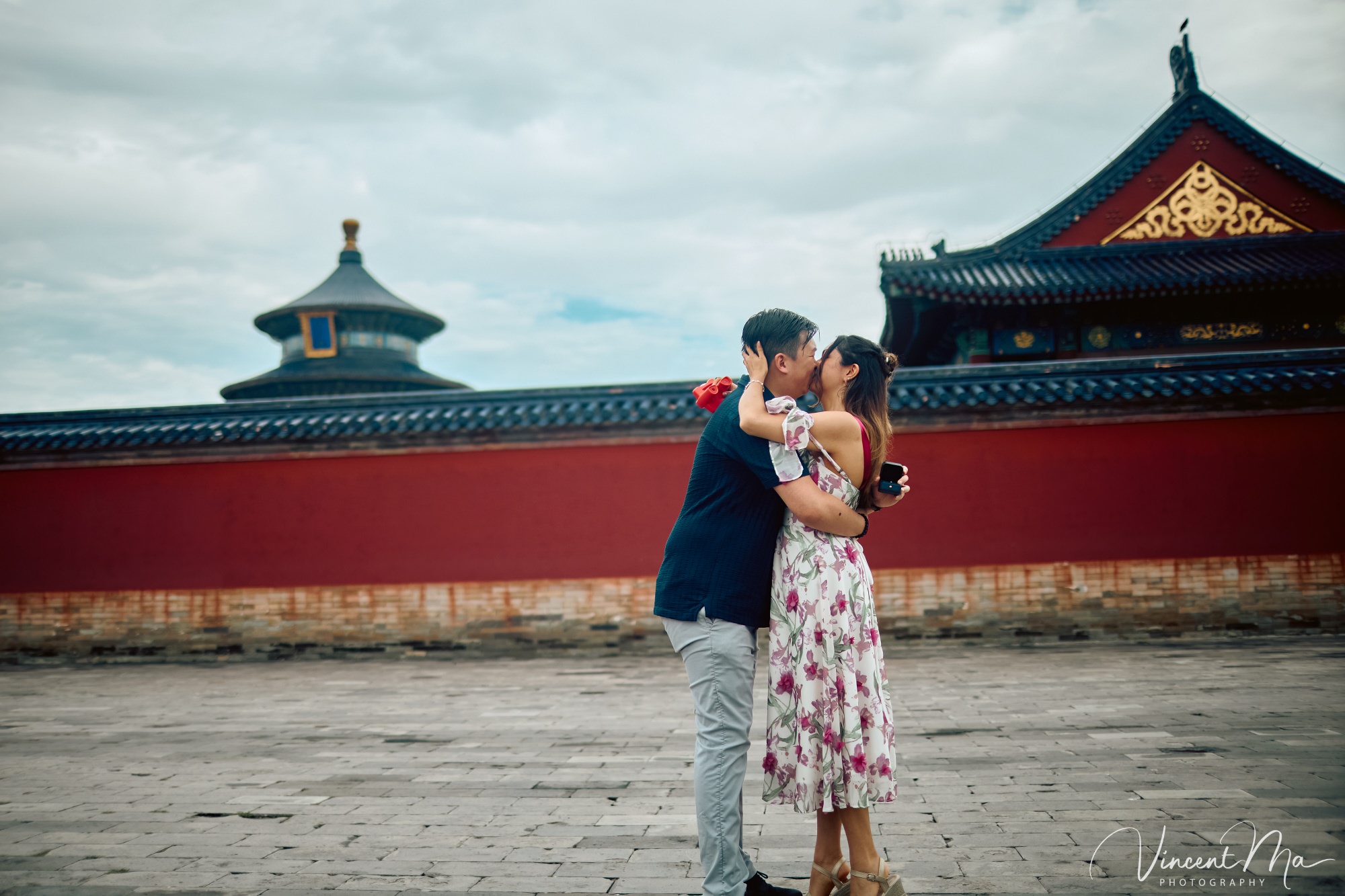 A foreign couple in traditional Chinese - style clothing, the man kneeling on one knee to propose to the woman in front of the majestic Hall of Prayer for Good Harvests in the Temple of Heaven