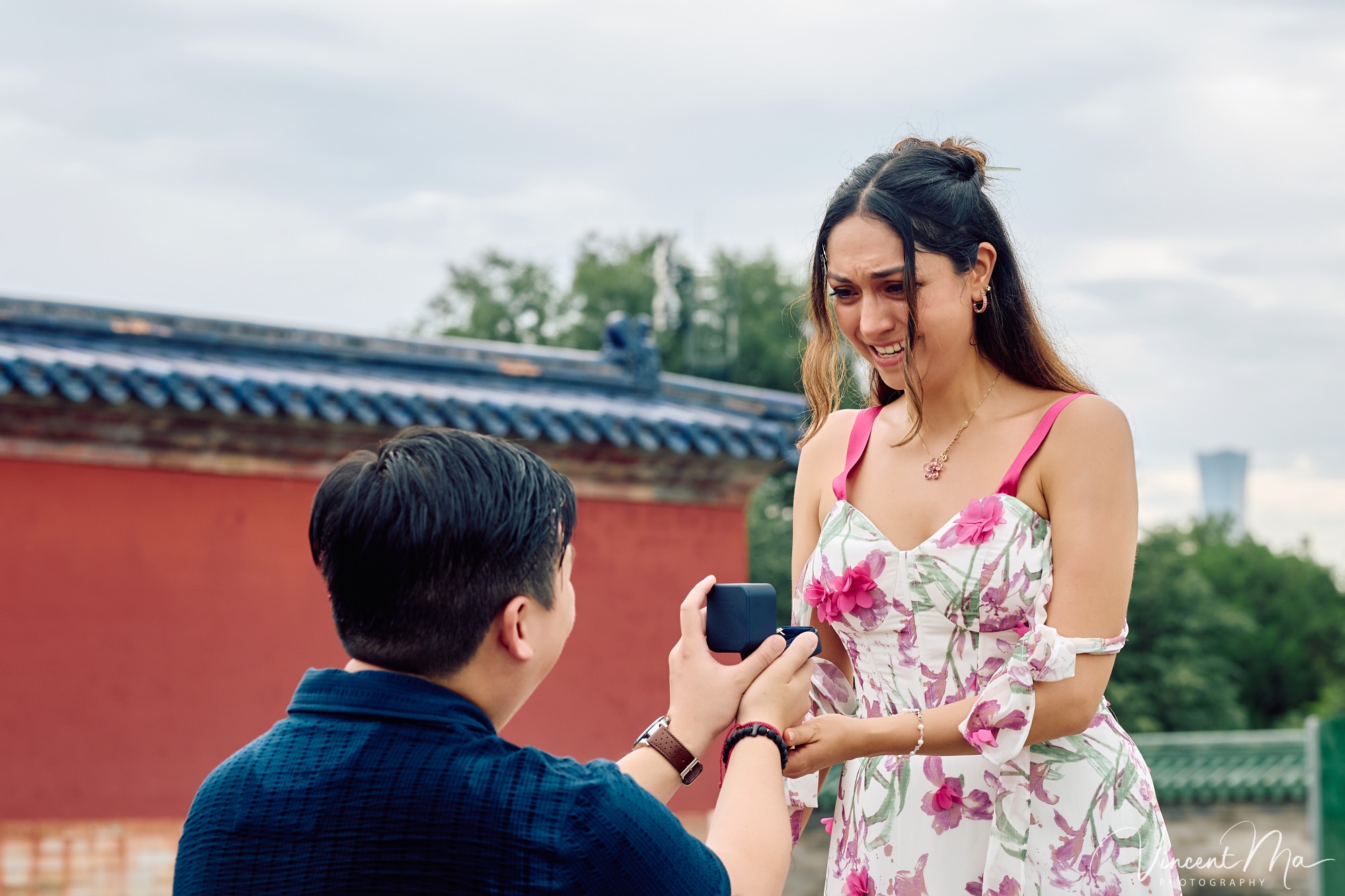 A foreign couple in traditional Chinese - style clothing, the man kneeling on one knee to propose to the woman in front of the majestic Hall of Prayer for Good Harvests in the Temple of Heaven
