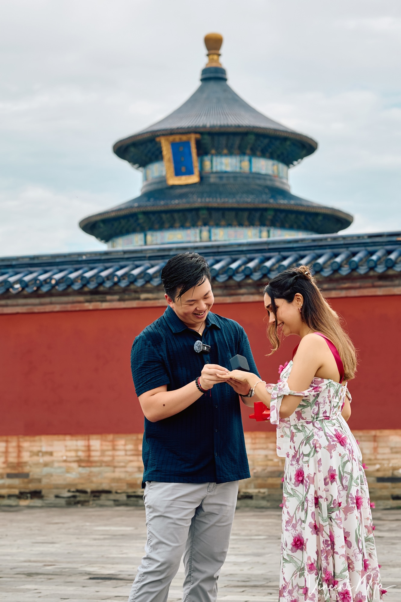 A foreign couple in traditional Chinese - style clothing, the man kneeling on one knee to propose to the woman in front of the majestic Hall of Prayer for Good Harvests in the Temple of Heaven