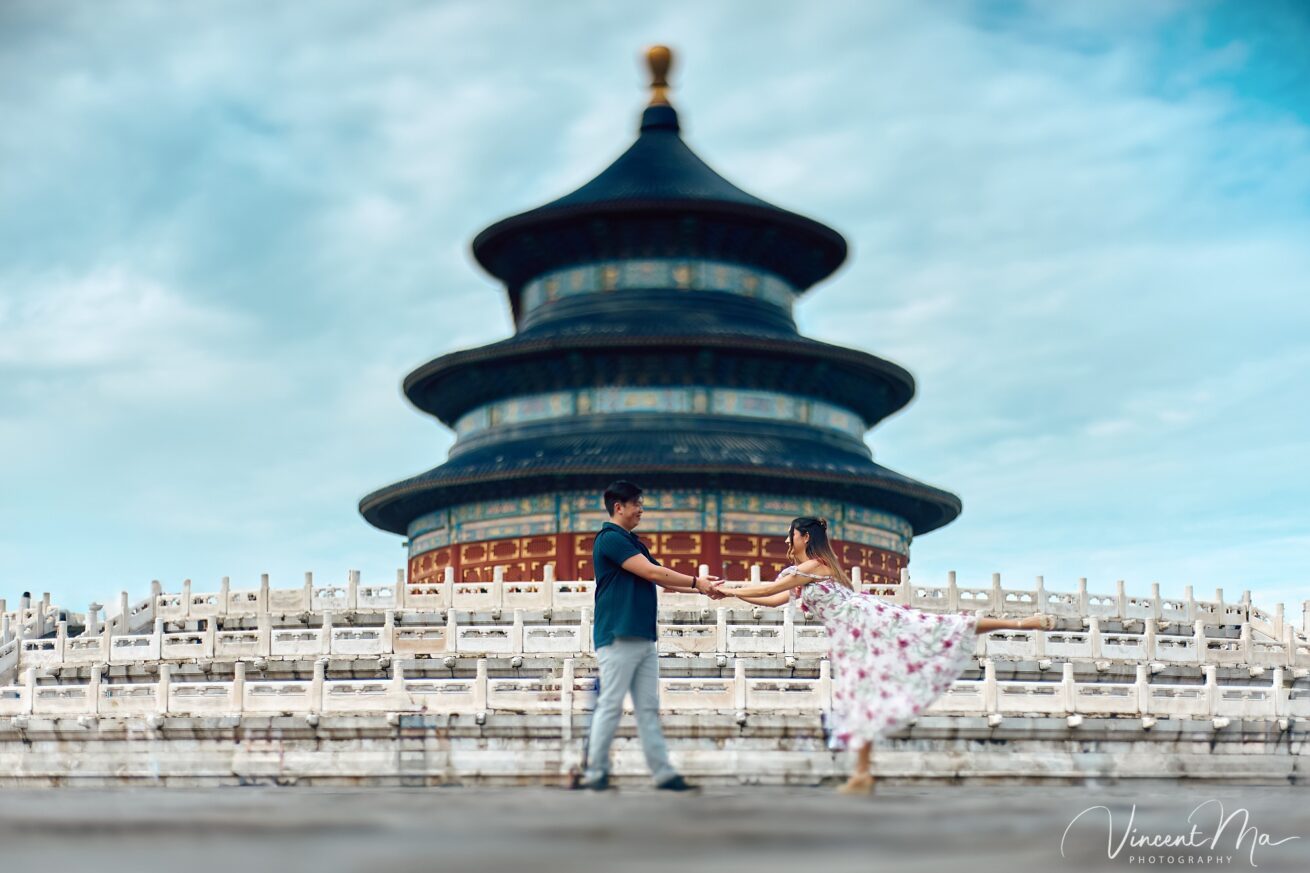 A foreign couple in traditional Chinese - style clothing, the man kneeling on one knee to propose to the woman in front of the majestic Hall of Prayer for Good Harvests in the Temple of Heaven