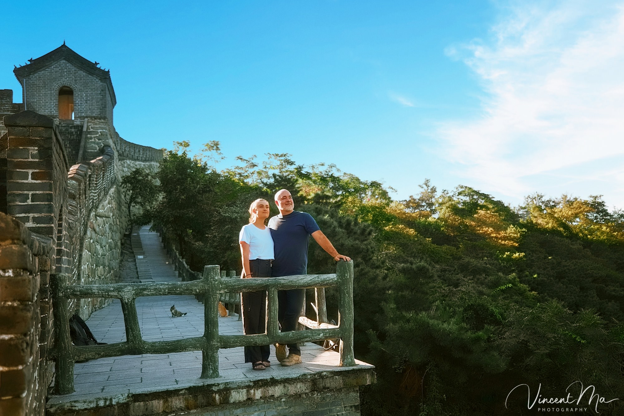 An American couple posing for romantic pictures against the backdrop of Mutianyu Great Wall in Beijing, China. The Great Wall winds through the mountains, and the couple shows their love in the photos