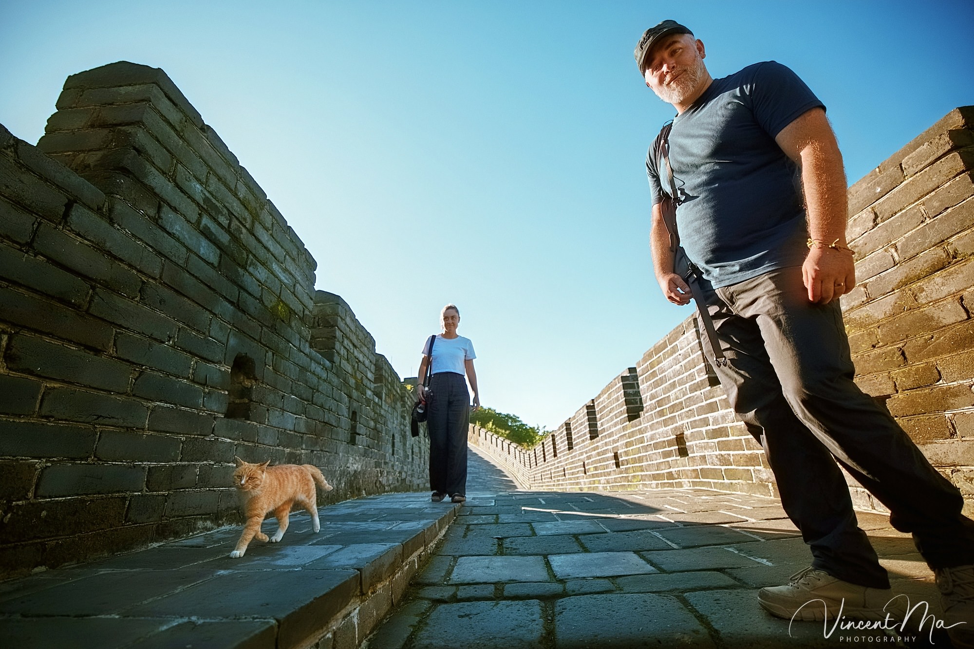 An American couple posing for romantic pictures against the backdrop of Mutianyu Great Wall in Beijing, China. The Great Wall winds through the mountains, and the couple shows their love in the photos