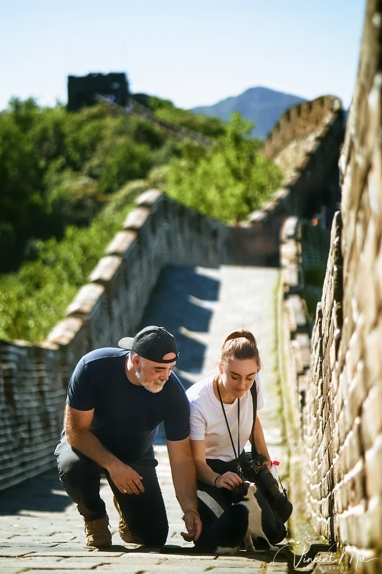 An American couple posing for romantic pictures against the backdrop of Mutianyu Great Wall in Beijing, China. The Great Wall winds through the mountains, and the couple shows their love in the photos