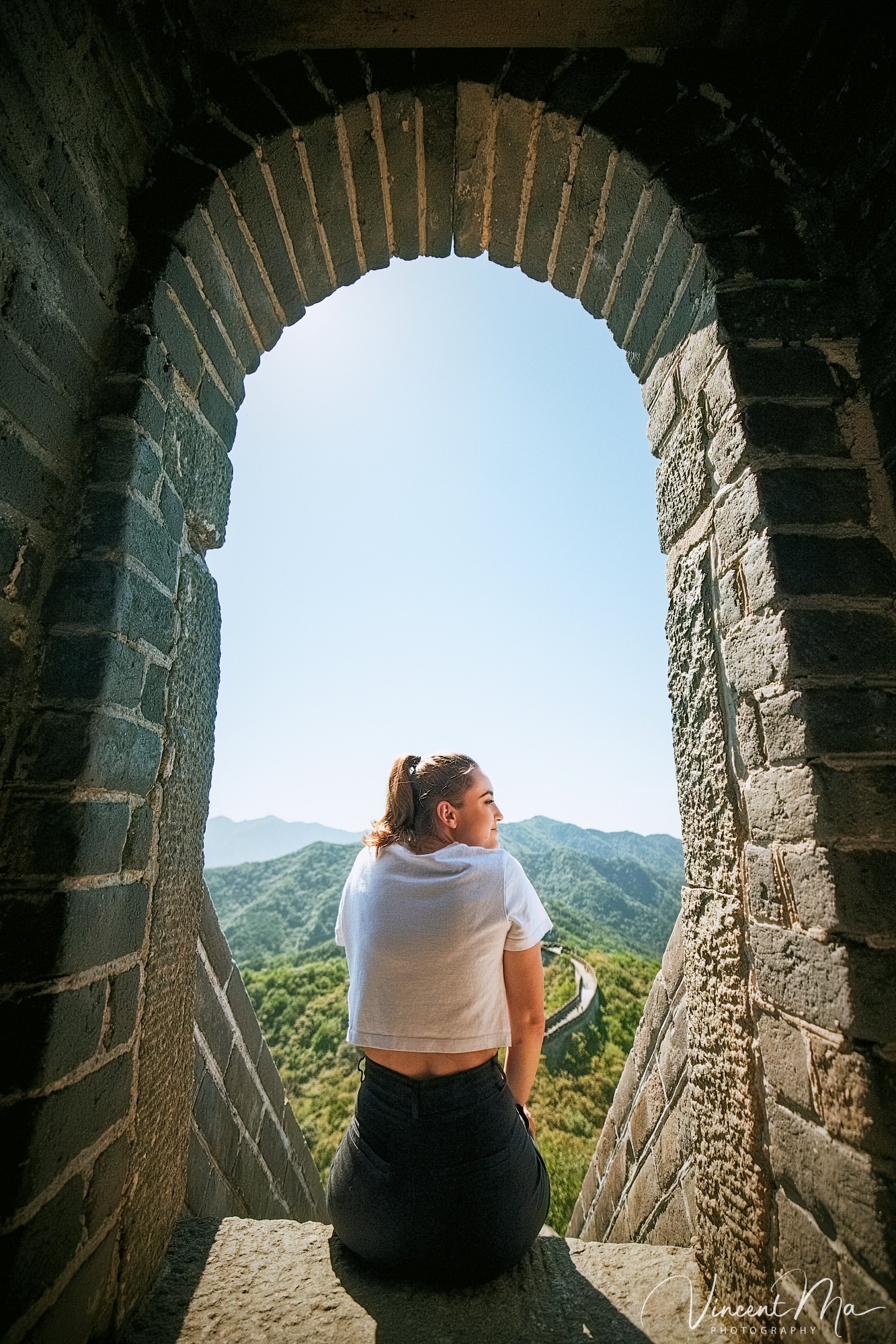 An American couple posing for romantic pictures against the backdrop of Mutianyu Great Wall in Beijing, China. The Great Wall winds through the mountains, and the couple shows their love in the photos