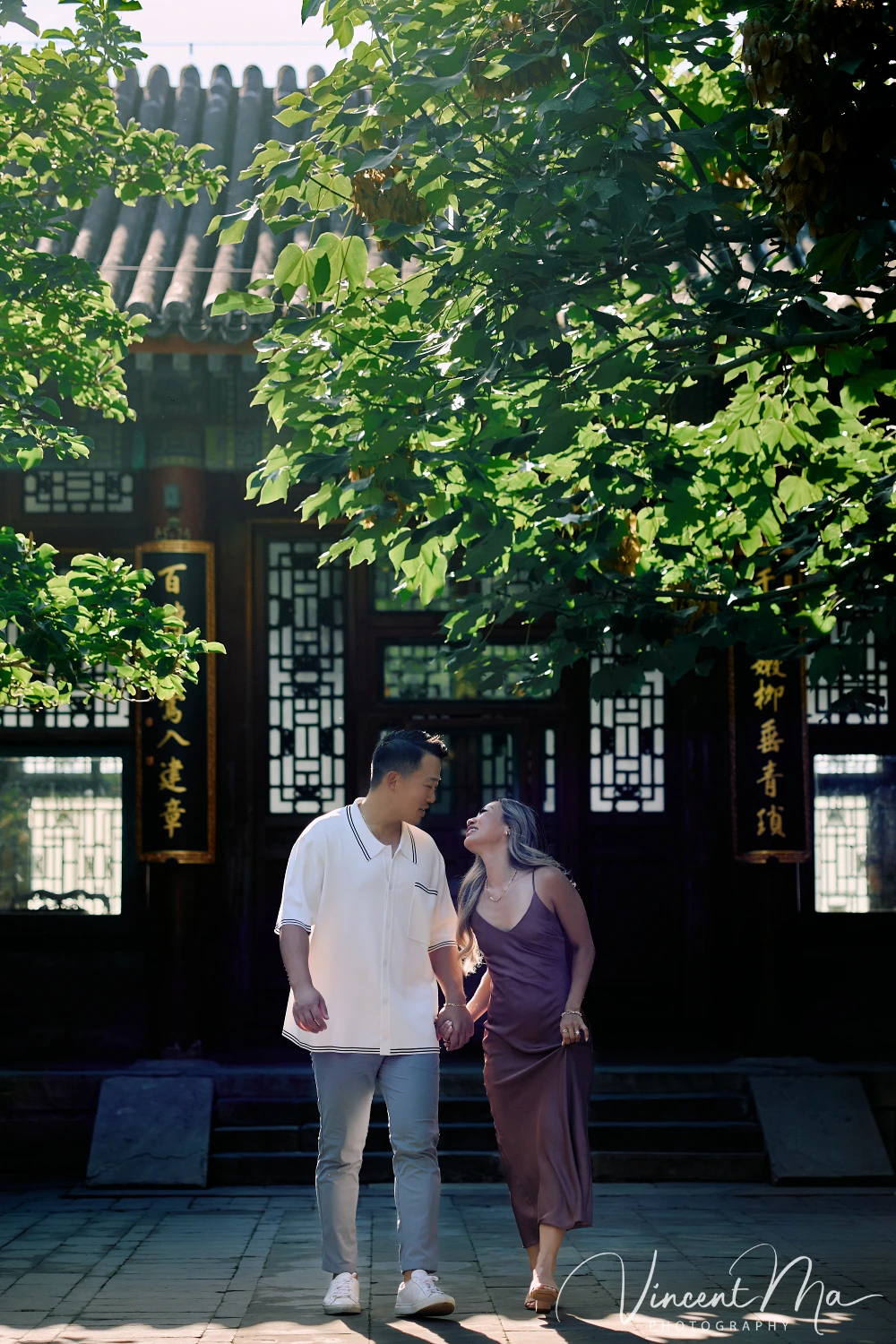 Couple enjoying a romantic moment at the Garden of Harmonious Interests in Beijing's Summer Palace, surrounded by traditional Chinese garden scenery with lakes and pavilions. Engagement shooting in summer palace.