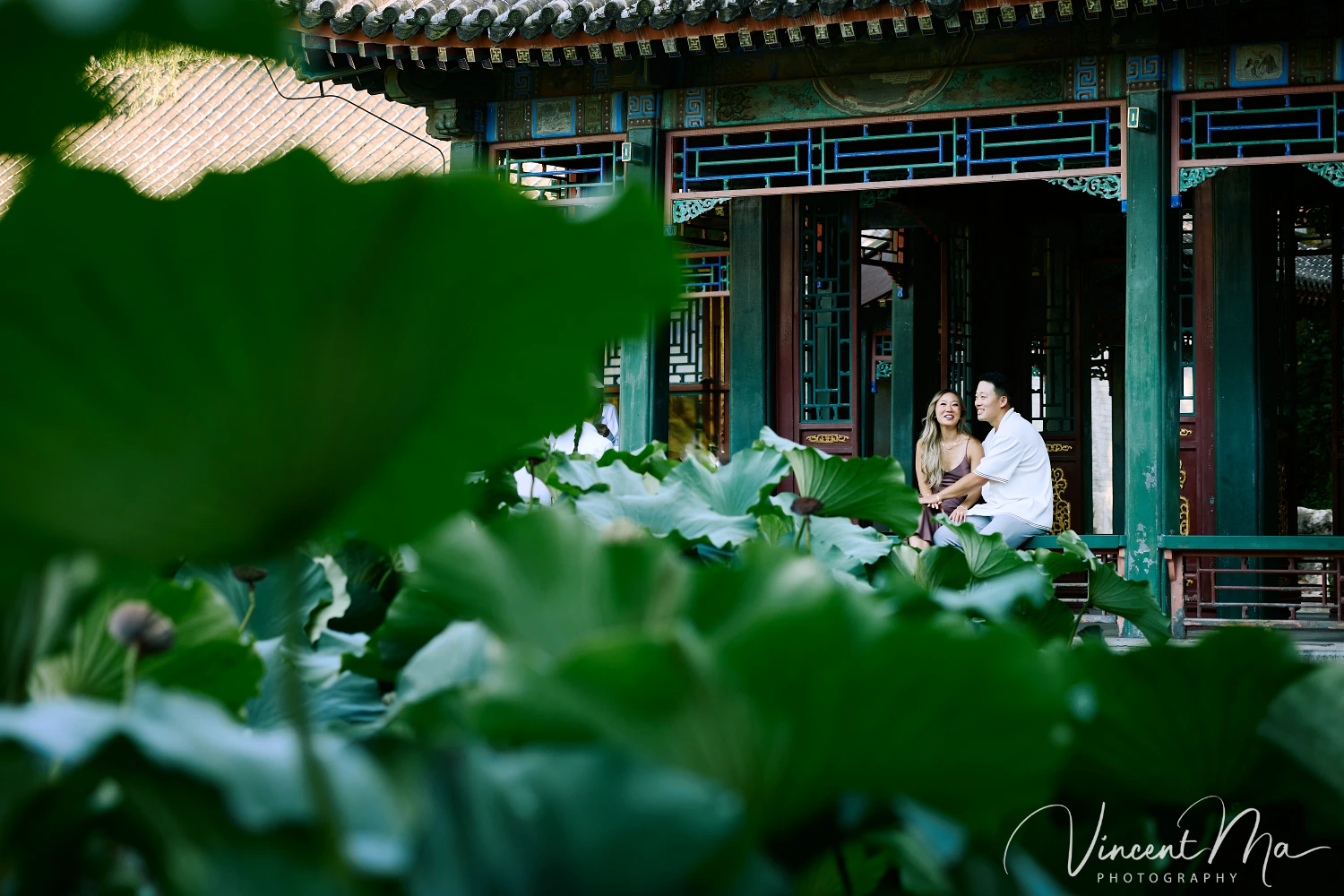 Couple enjoying a romantic moment at the Garden of Harmonious Interests in Beijing's Summer Palace, surrounded by traditional Chinese garden scenery with lakes and pavilions. Engagement shooting in summer palace.