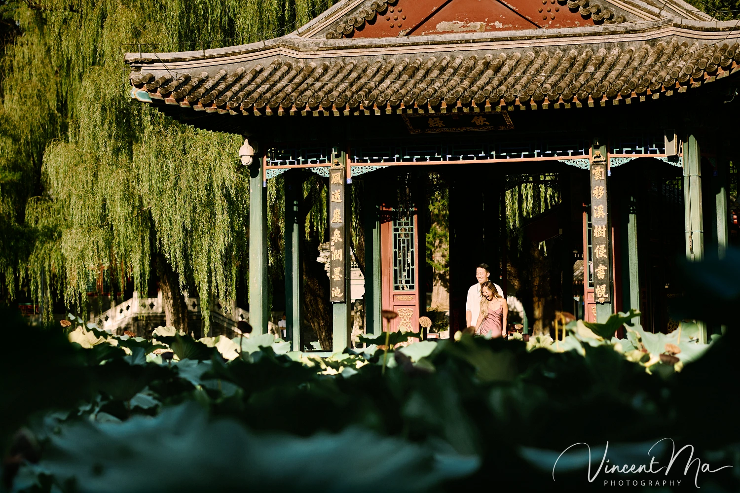 Couple enjoying a romantic moment at the Garden of Harmonious Interests in Beijing's Summer Palace, surrounded by traditional Chinese garden scenery with lakes and pavilions. Engagement shooting in summer palace.