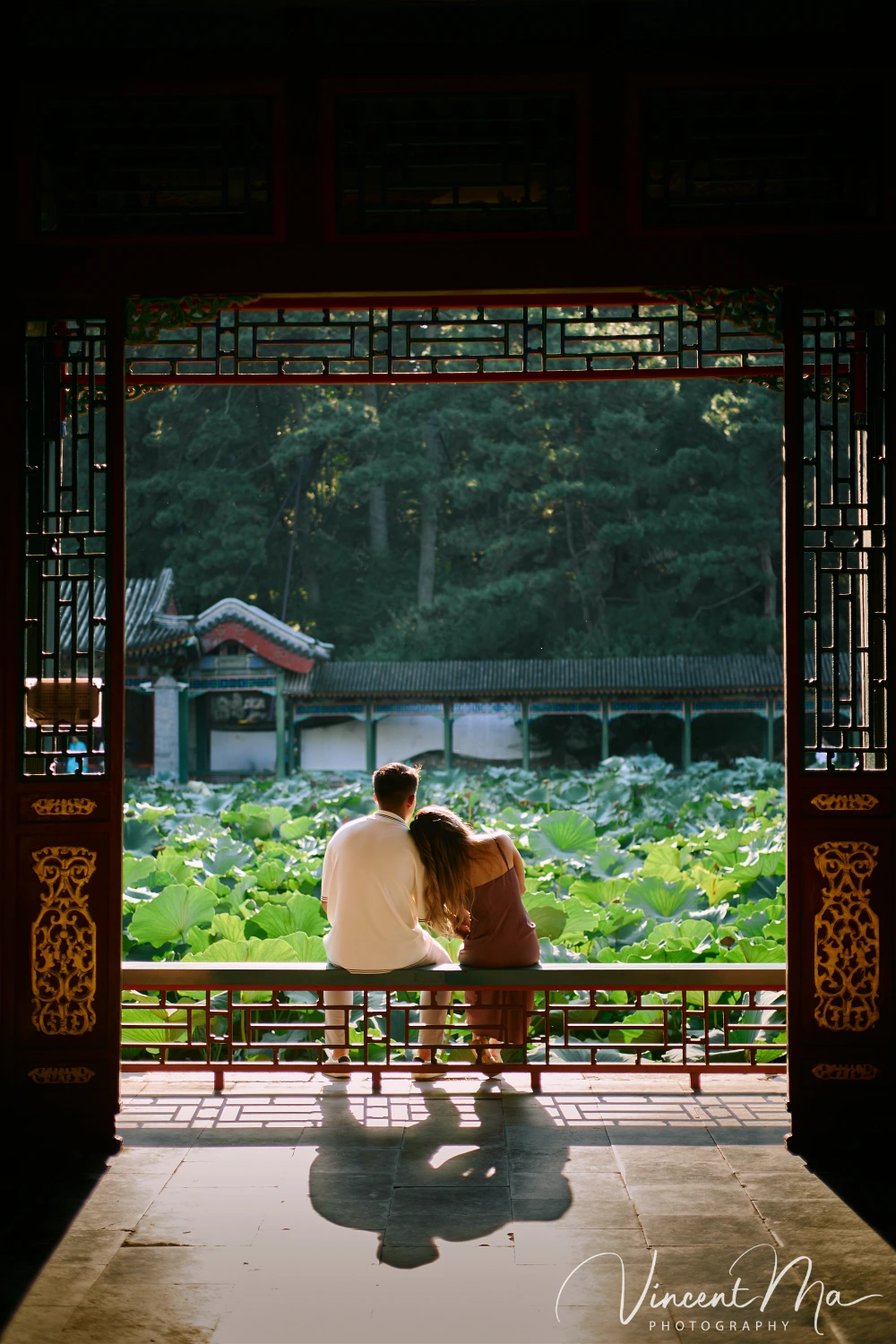 Couple enjoying a romantic moment at the Garden of Harmonious Interests in Beijing's Summer Palace, surrounded by traditional Chinese garden scenery with lakes and pavilions. Engagement shooting in summer palace.