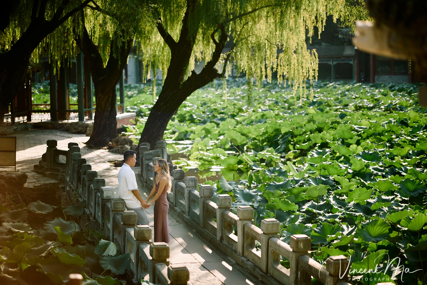 Couple enjoying a romantic moment at the Garden of Harmonious Interests in Beijing's Summer Palace, surrounded by traditional Chinese garden scenery with lakes and pavilions. Engagement shooting in summer palace.