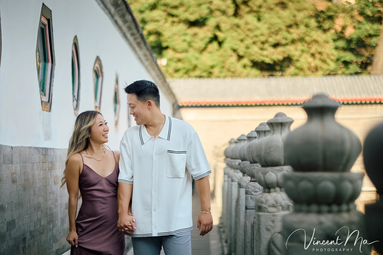 Couple enjoying a romantic moment at The Long Corridor in Beijing's Summer Palace, surrounded by traditional Chinese garden scenery with lakes and pavilions. Engagement shooting in summer palace. 