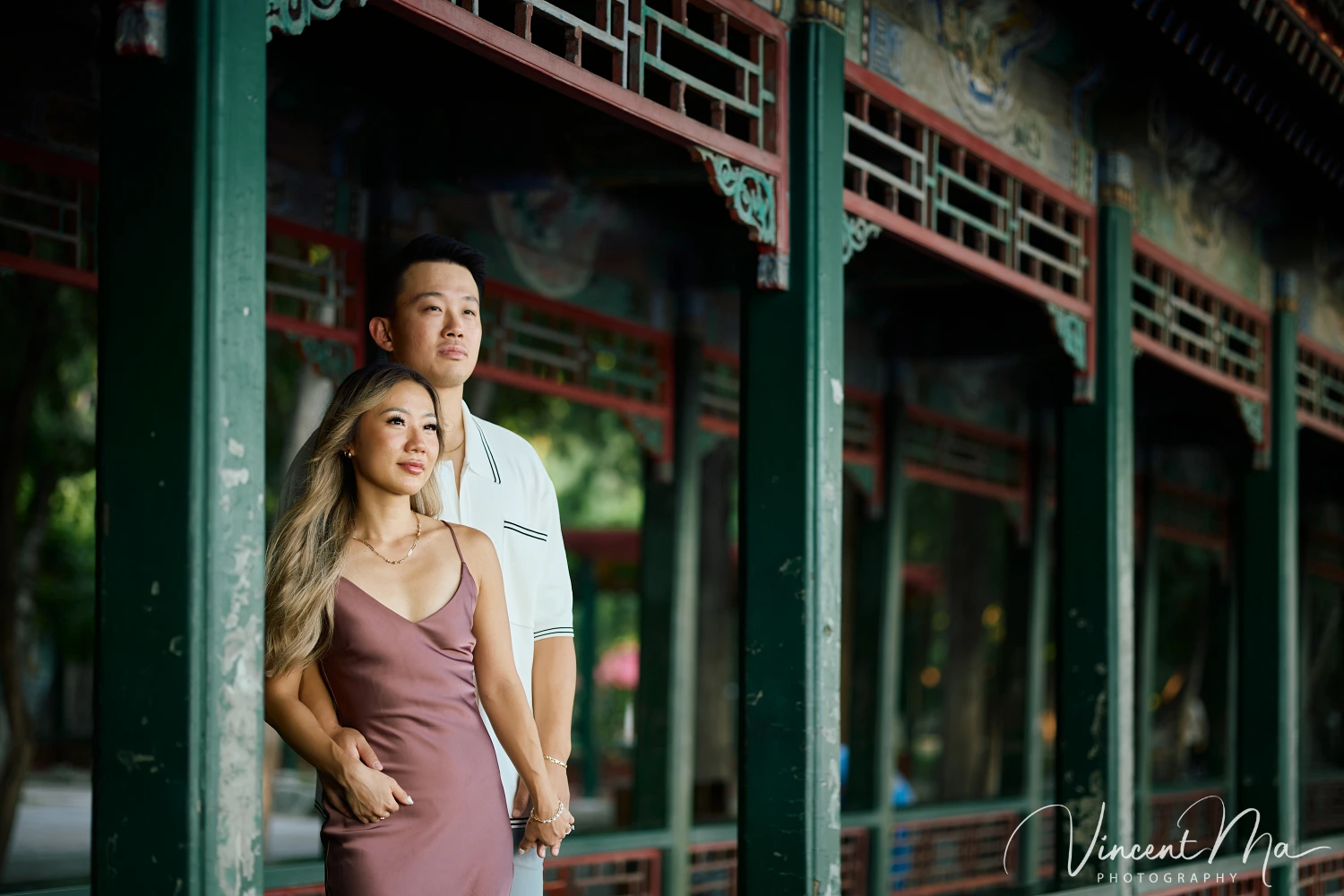 Couple enjoying a romantic moment at The Long Corridor in Beijing's Summer Palace, surrounded by traditional Chinese garden scenery with lakes and pavilions. Engagement shooting in summer palace. 