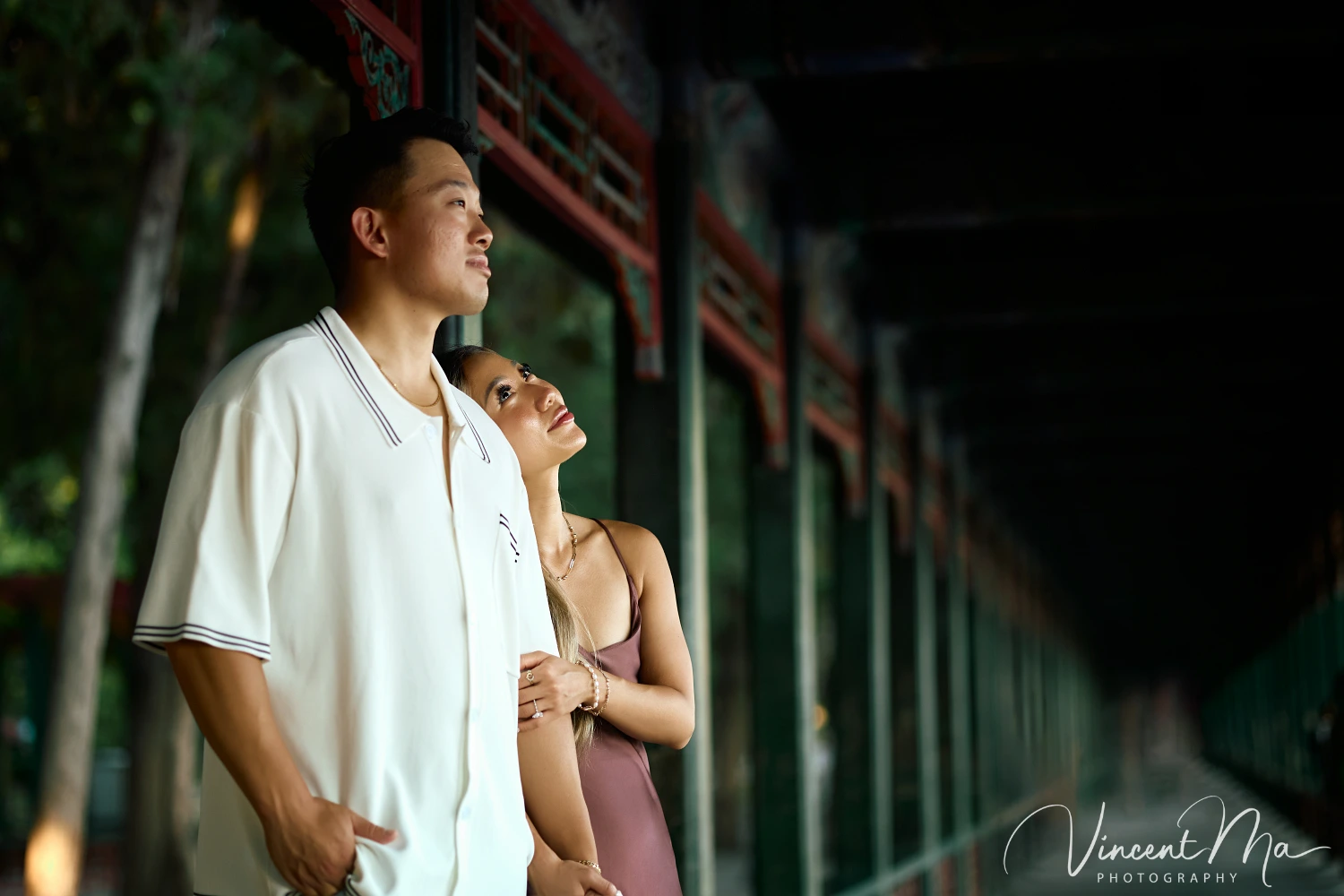 Couple enjoying a romantic moment at The Long Corridor in Beijing's Summer Palace, surrounded by traditional Chinese garden scenery with lakes and pavilions. Engagement shooting in summer palace. 
