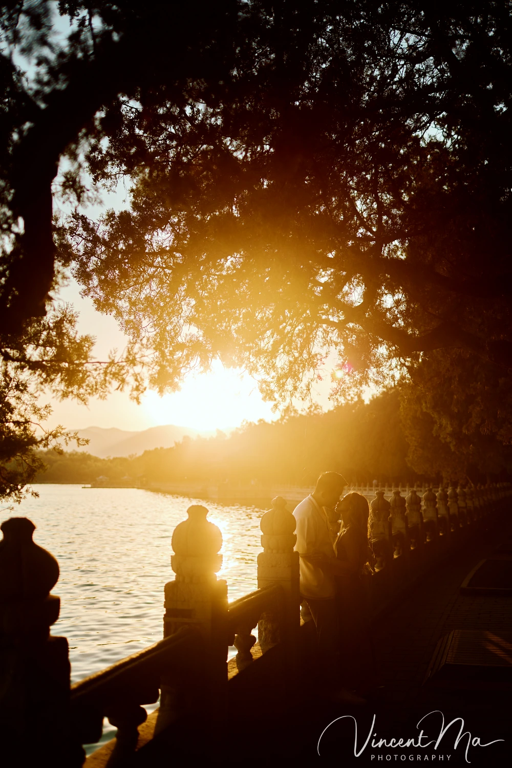 A couple shares an intimate moment with the magnificent architecture of the Summer Palace in sunset in the background.