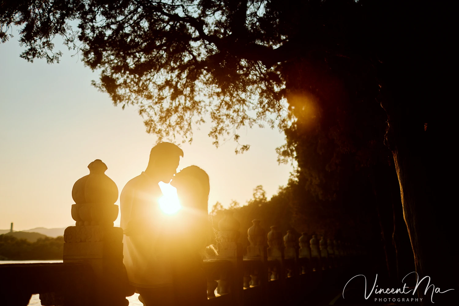 A couple shares an intimate moment with the magnificent architecture of the Summer Palace in sunset in the background.