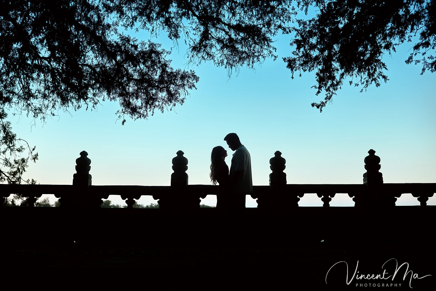 A couple shares an intimate moment with the magnificent architecture of the Summer Palace in Beijing in the background.