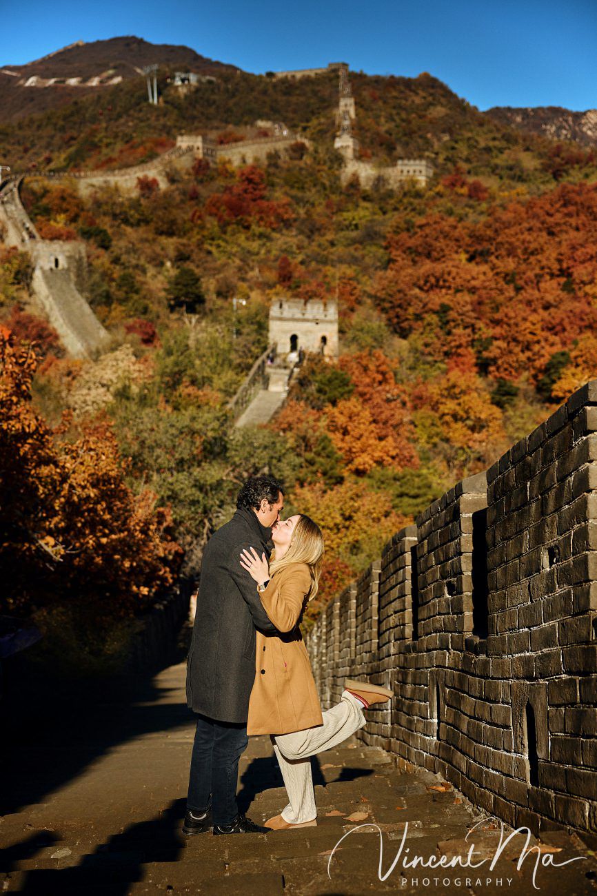Surprise marriage proposal engagement shooting on Mutianyu Great Wall with ancient bricks and autumn leaves in background