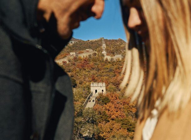 Surprise marriage proposal engagement shooting on Mutianyu Great Wall with ancient bricks and autumn leaves in background