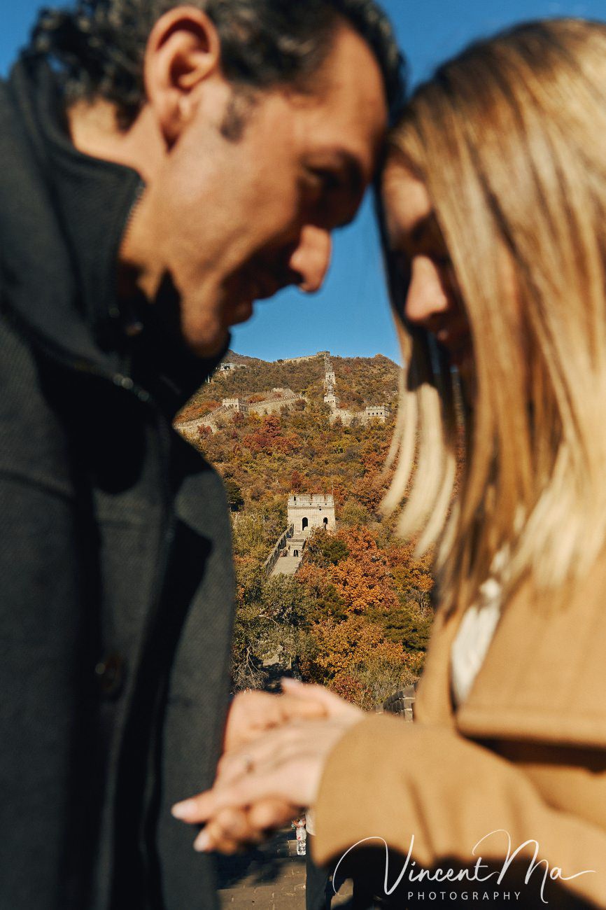 Surprise marriage proposal engagement shooting on Mutianyu Great Wall with ancient bricks and autumn leaves in background