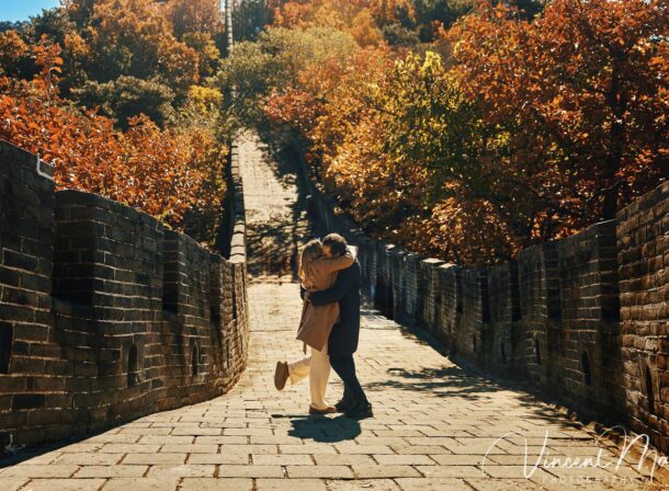 Surprise marriage proposal engagement shooting on Mutianyu Great Wall with ancient bricks and autumn leaves in background