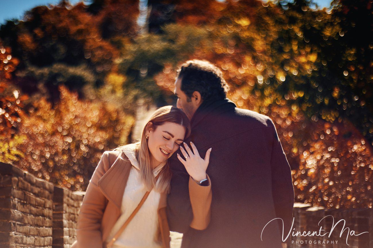 Surprise marriage proposal engagement shooting on Mutianyu Great Wall with ancient bricks and autumn leaves in background