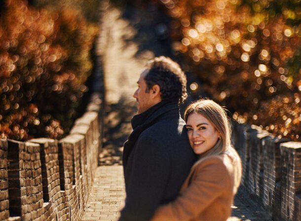 Surprise marriage proposal engagement shooting on Mutianyu Great Wall with ancient bricks and autumn leaves in background