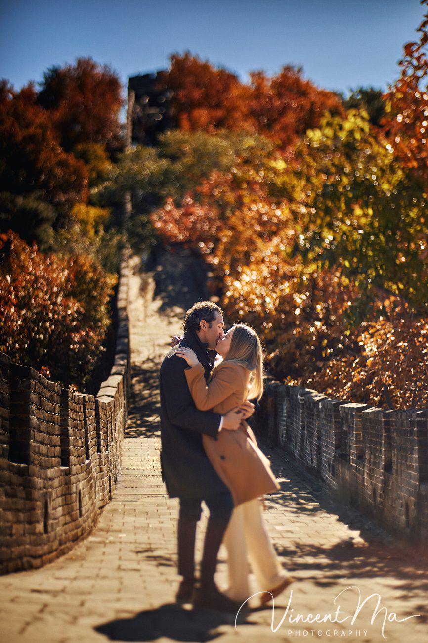 Surprise marriage proposal engagement shooting on Mutianyu Great Wall with ancient bricks and autumn leaves in background
