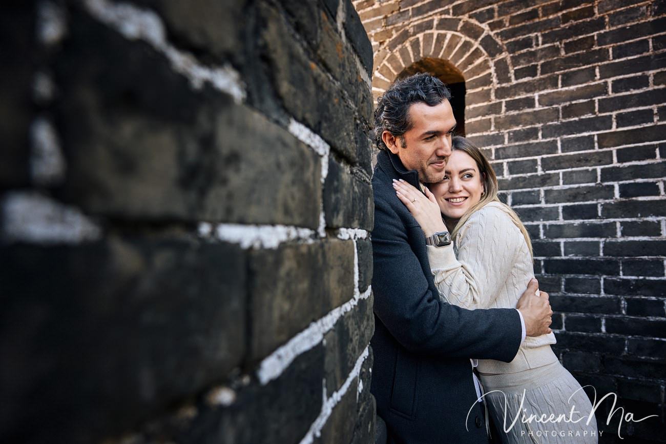 Surprise marriage proposal engagement shooting on Mutianyu Great Wall with ancient bricks and autumn leaves in background